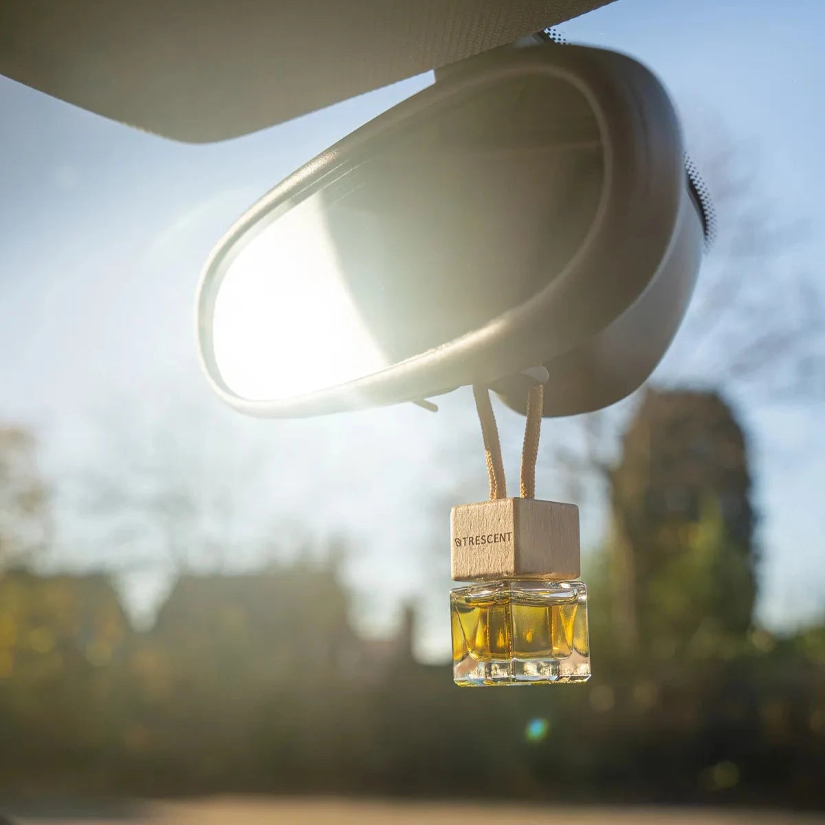 Autoparfum Trescent aan spiegel met zon